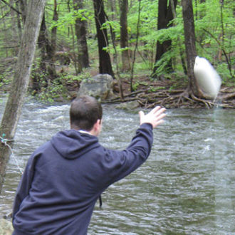 Stamford MS student tests stream flow rate in Mianus River - horizontal