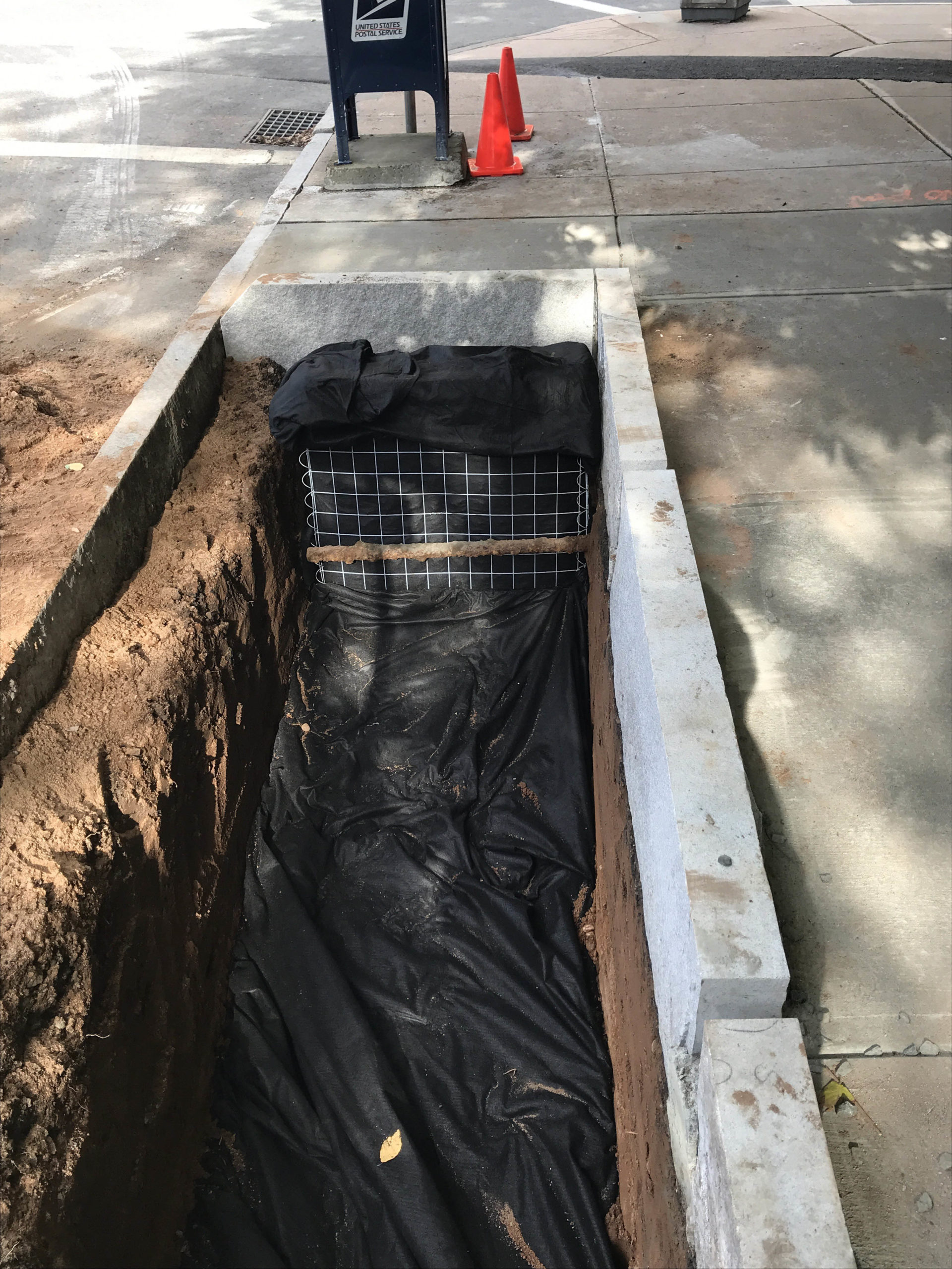 A bioswale is prepared and filled with coarse gravel. The gravel and gabion of the bioswale are wrapped in a permeable geotextile fabric.