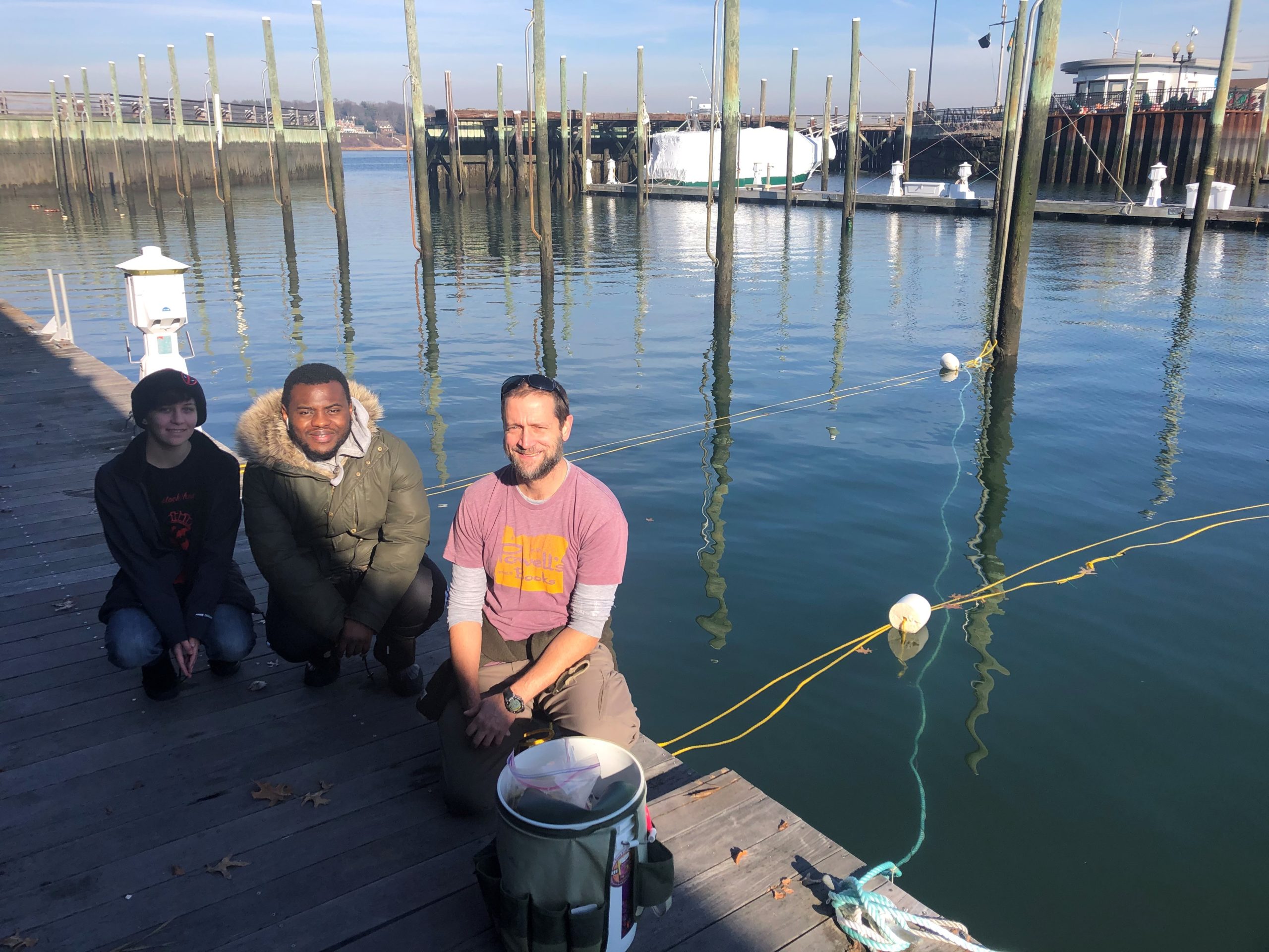 Dr. Aaren Freeman, a marine scientist at  Adelphi University (right), and  Adelphi students Amanda Hornung and Thierno Diallo pose for a picture after a day of seeding long lines with juvenile kelp seed. Photo courtesy of Dave Gugerty.