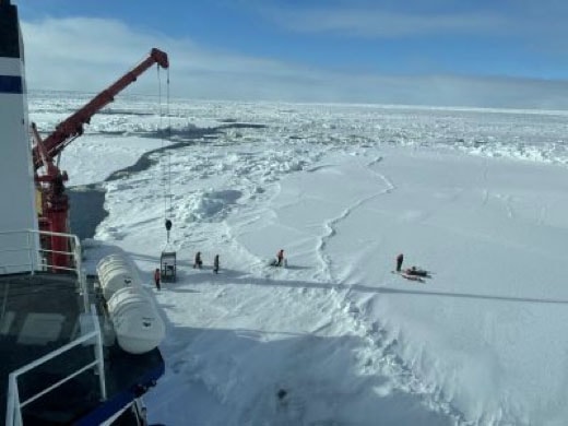 Researchers drilling into the ice in the Arctic to collect ice cores and under-ice water samples. 