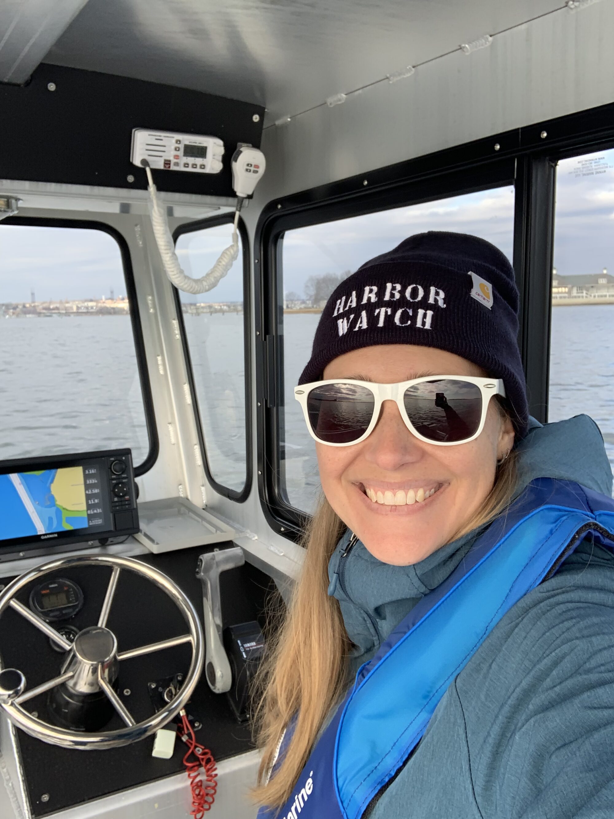A selfie of Nikki Spiller steering a research vessel. 