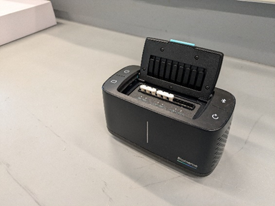 A black box machine on a lab counter.